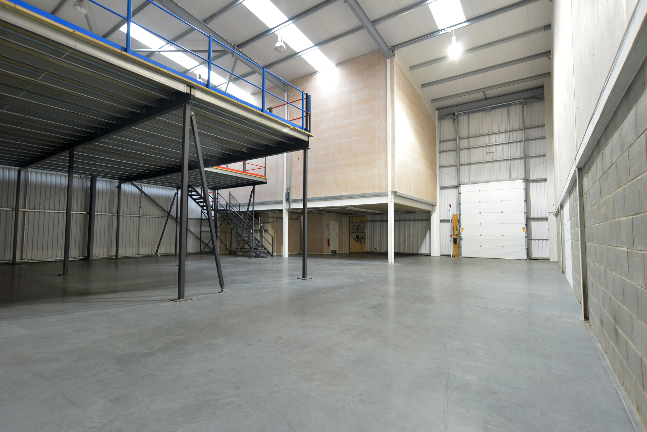 Spacious interior of the Wilkinsons Distribution Centre featuring steel partitions, epoxy resin flooring, and a mezzanine level, designed for efficient workspace functionality.