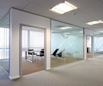 Glazed office partition with manifestation decals and a meeting room visible through the glass
