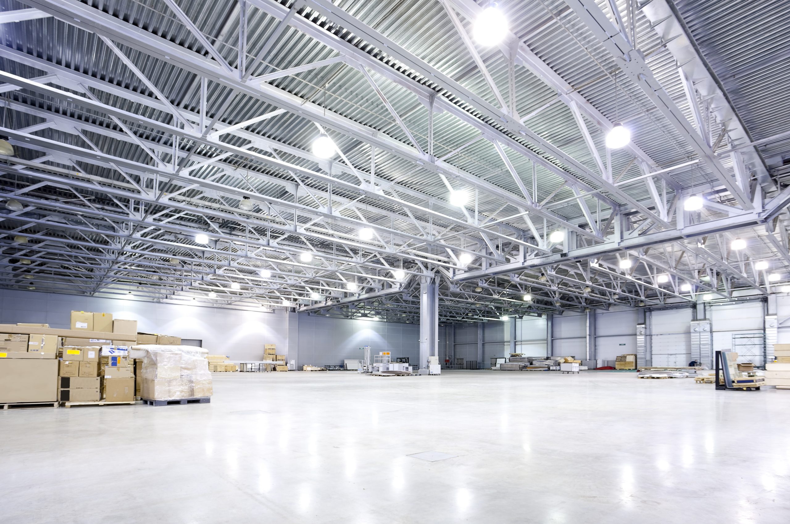 Spacious warehouse interior showcasing robust steel structure, high ceilings, and organized storage with cardboard boxes, emphasizing the functional design of the Wilkinsons Distribution Centre fit-out project by Interior Systems Wales.